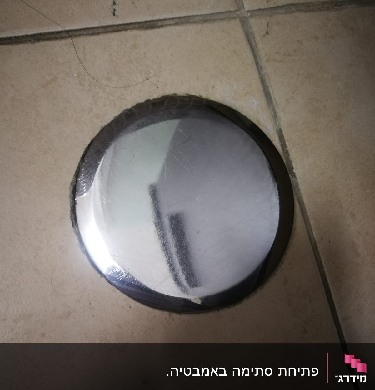 כיסוי מתכת עגול על רצפת קרמיקה